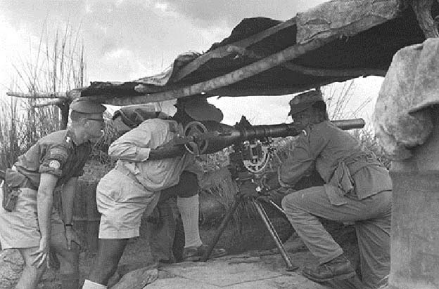 Le lieutenant Liston et le major Yossa, commandant du 2e bataillon congolais, vérifient l'arc de tir de ses armes antichars sans recul. Kamina, 1962.