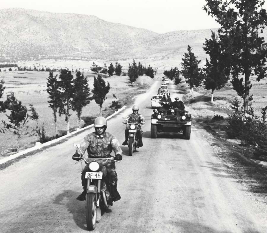 Les véhicules civils, contenant souvent des passagers chypriotes grecs, étaient gardés par une troupe canadienne de Ferret Scout Cars, pour le trajet entre Nicosie et Kyrenia. Plusieurs fois par jour, le secteur turc est traversé en toute sécurité sous escorte armée. Le Ltn Doug Taylor commande sa troupe et l'opération après avoir rassemblé les véhicules au point de contrôle.