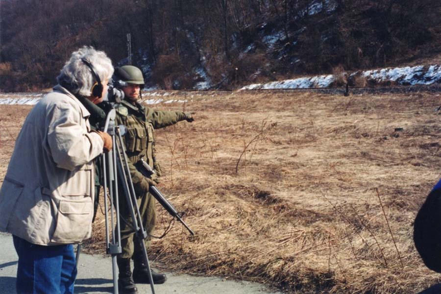 Un soldat canadien indique un champ de mines anti-personnel au journaliste de Global News, Claude Adams, lors d'une patrouille de présence en Bosnie, en mars 1999. 